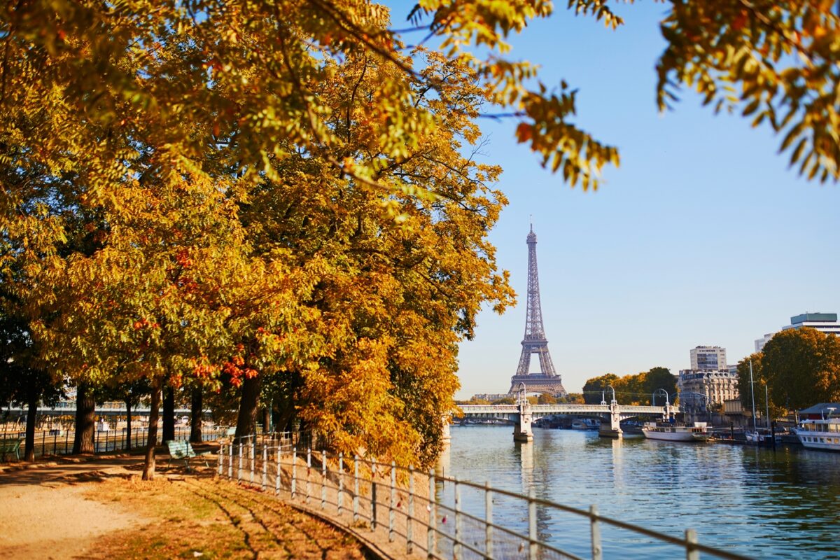 Autumn orange leaves in Paris with the Eiffel Tower in the background and the  River Seine on the right hand side. 