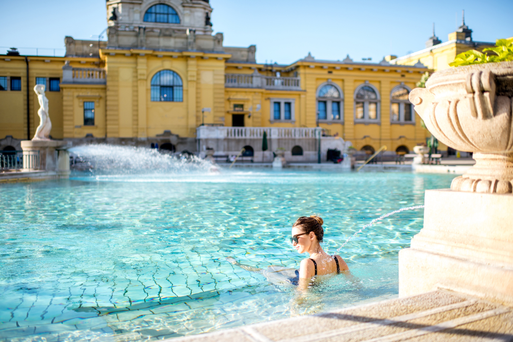 Young woman relaxing with water jet at the famous Szechenyi thermal bathes in Budapest. It is one of the biggest natural hot spring spa baths in Europe