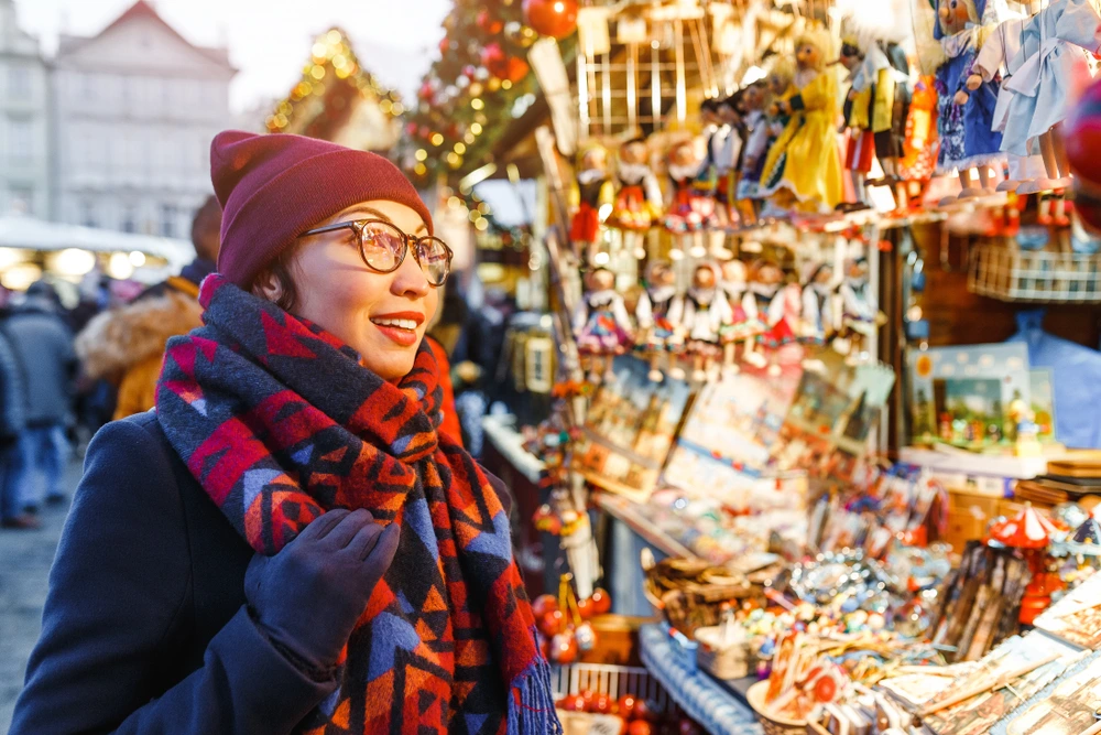 Woman exploring Christmas market in Prague, as one of the best Christmas markets in Europe.